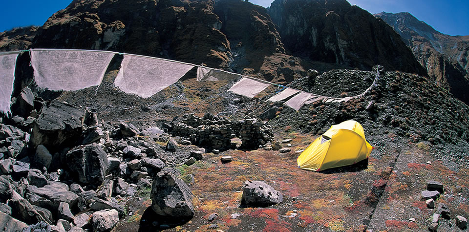 A yellow Lightwave tent pitched in a mountain landscape